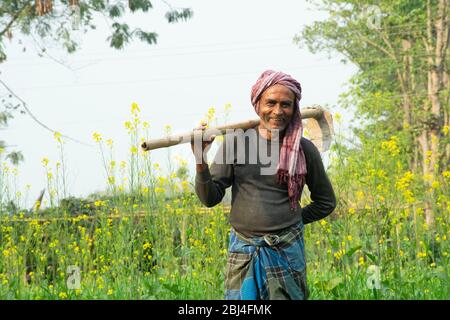 portrait of indian farmer holding hoe on shoulder Stock Photo