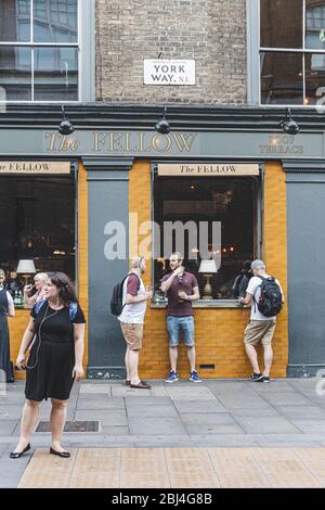 London/UK-26/07/18: people socializing just outside The Fellow Pub on York Way near King's Cross. Pubs are a social drinking establishment and a promi Stock Photo