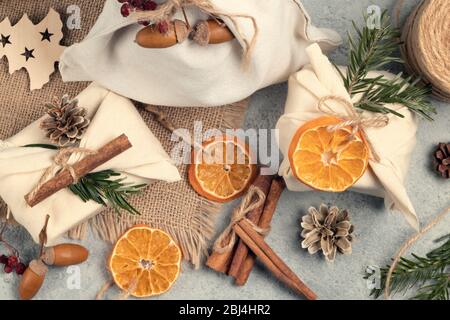 Zero waste christmas concept. Packed in natural fabric gifts and decorations from natural materials on a gray table, top view, Stock Photo