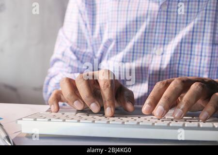 young man typing on keyboard in office Stock Photo