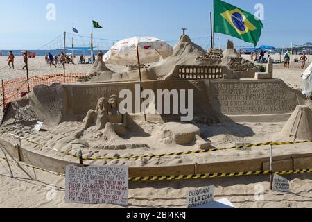 Sandcastle and people carved on Copacabana Beach, with the flag on Brazil, Rio De Janeiro Stock Photo