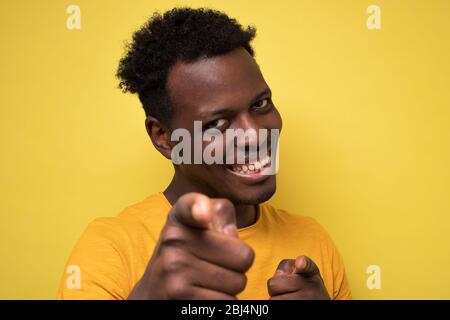 Cheerful attractive african man pointing on you making a choice. Stock Photo
