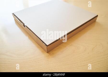 Blank brown cardboard Pizza paper box isolated on the table. Stock Photo