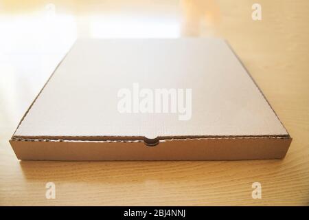 Blank brown cardboard Pizza paper box isolated on the table. Stock Photo