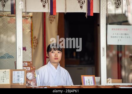 A sales woman at the Enoshima Shrine is selling souvenirs, Omikuji and Ema for visitors. Stock Photo