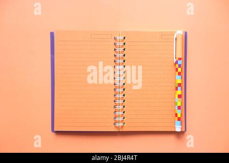 high angle view of notebook with pen on orange background  Stock Photo