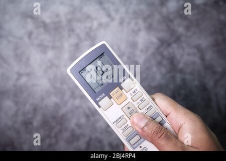 Air conditioner temperature adjustment with remote controller Stock Photo