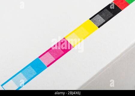 Colour registration strip on paper packaging. For CMYK process colours, spot colours, printing registration, colours in industry, industrial process Stock Photo