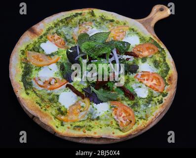 Thin crust pizza with basil pesto and tomato Stock Photo