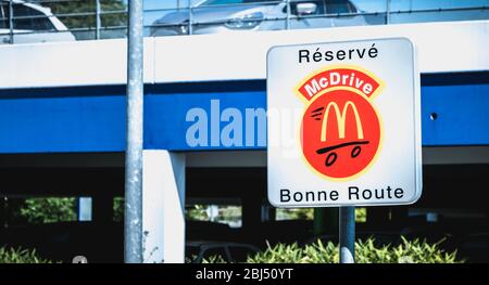 Libourne, France - May 26, 2017: Road sign indicating a place reserved for McDrive customers in the parking lot of a McDonald s restaurant on a spring Stock Photo