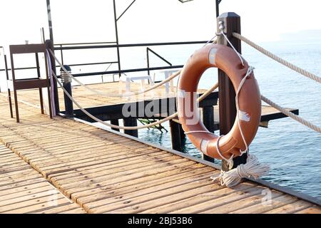 A life buoy hangs on the pier's handrail Stock Photo