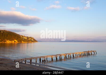Wooden jetty at Dassia beach at sunrise, Corfu, Greece Stock Photo