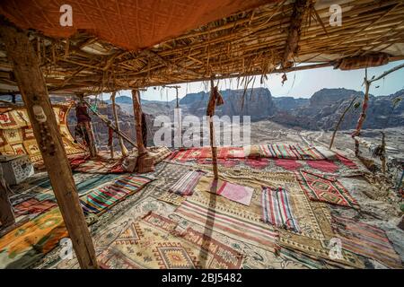 A colourful Bedouin dwelling outfitted with comfortable rugs overlooks the desert near Petra in Jordan. Stock Photo