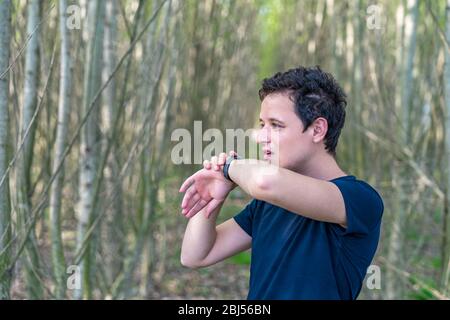 man speaks to smart watch when telephoning in nature Stock Photo