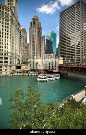 Ferry boat passes under the DuSable Bridge over the Chicago River in downtown Chicago Illinois USA during a summer day Stock Photo