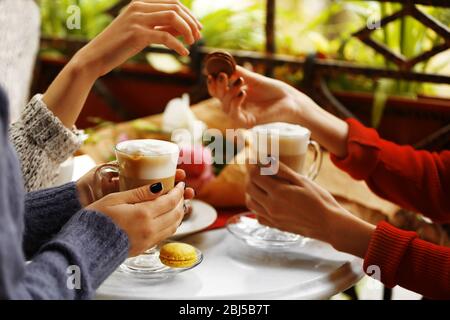 Women meeting in cafe and drinking latte Stock Photo