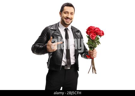 Handsome man in a leather jacket holding a bunch of roses and pointing isolated on white background Stock Photo