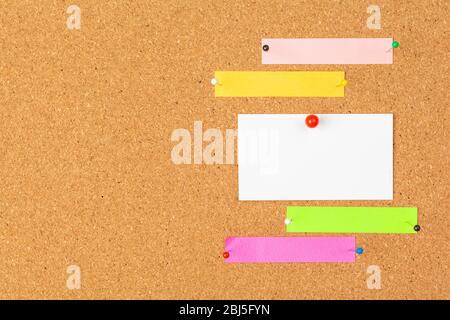 Cork board with several colorful blank notes with pins Stock Photo