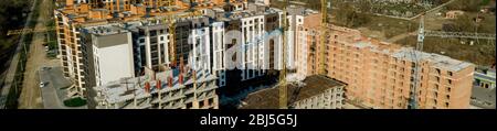 Construction and construction of high-rise buildings, the construction industry with working equipment and workers. View from above, from above Stock Photo