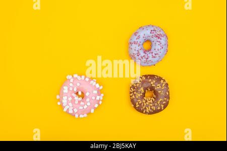 Sweet chocolate donuts on yellow background. Dessert food Stock Photo