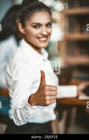 Smiling businesswoman shows Thumbs Up Gesture Stock Photo