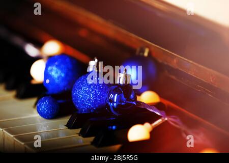 Piano keys decorated with decorative lights and balls, close up Stock Photo