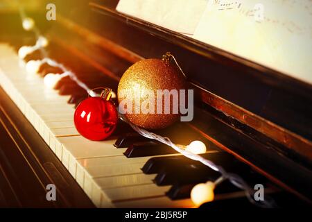 Piano keys decorated with decorative lights and balls, close up Stock Photo