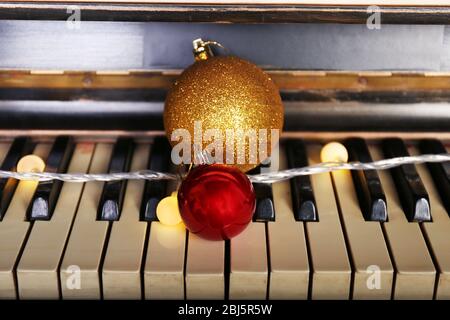 Piano keys decorated with decorative lights and balls, close up Stock Photo