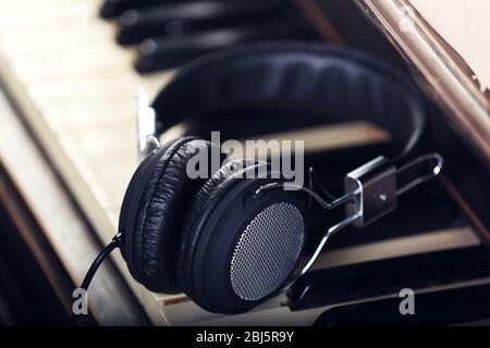 Headphones on piano keyboard, close up Stock Photo