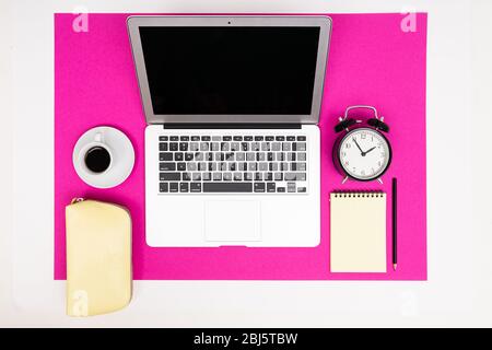School and office supplies such as note, pens, pencils and other lie neatly on a pink background