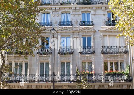 Typical design of Parisian architecture. The facade of french building in modern style with windows and french balconies in Paris, France. Stock Photo