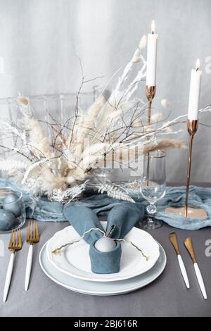 Setting easter table with candles and colored eggs Stock Photo