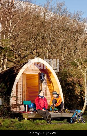 couple getting ready for a hike in front of camping pod Stock Photo