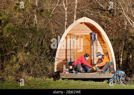 couple preparing for a hike in front of camping pod in the UK Stock Photo