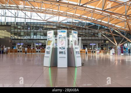 Hamburg, Germany - March 29 2020: Self check in machines in the departure terminal, airport in Hamburg, with no passengers because of the Covid-19 pan Stock Photo
