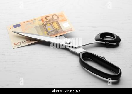 Scissors cuts euro banknote on table Stock Photo