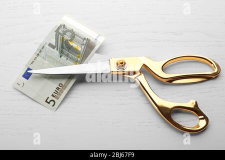 Scissors cuts euro banknote on table Stock Photo