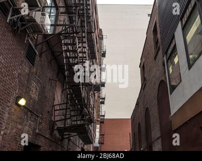 Fire escape stairs and ladder, in metal, on a typical North American old brick building from the Old Montreal, Quebec, Canada.   Picture of fire escap Stock Photo