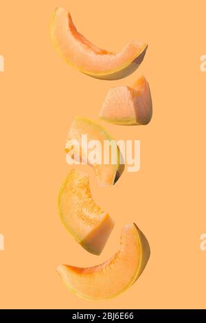Falling fresh melon isolated on colored background Stock Photo