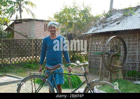 rural man standing in front of his house with cycle Stock Photo