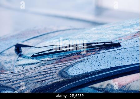 Side view of close-up of new car wipers on the full with raindrops windshield Stock Photo