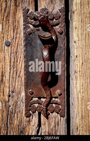 A detailed view of the snake door handle on a 400-year old door adorns Mission San Xavier del Bac south of Tucson, Arizona. Stock Photo