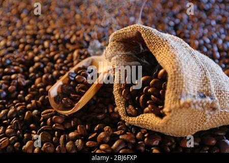Sackcloth bag with coffee beans on coffee beans background Stock Photo