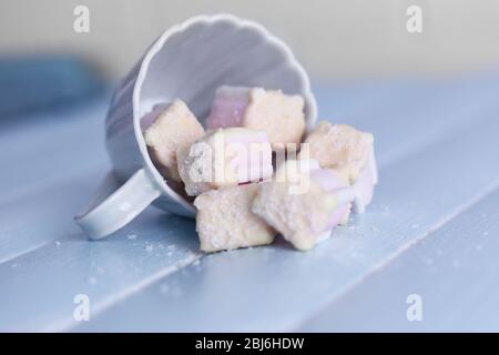 Tasty marshmallows with chocolate in cup on table, close up Stock Photo