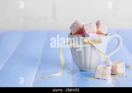 Tasty marshmallows with chocolate in cup on table, close up Stock Photo