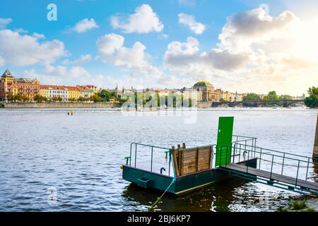 Beautiful sky with clouds and a setting sun from the Kampa Island riverbanks along the Vltava River with Old Town Prague, Czechia in view. Stock Photo