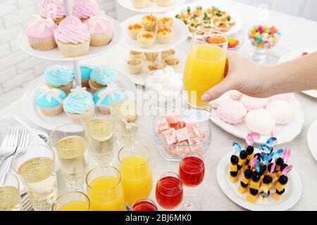 Woman holding glass of juice on buffet background Stock Photo