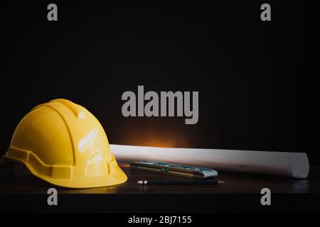 real estate, property and construction project concept, engineer's tools  with helmet on table in dark background Stock Photo