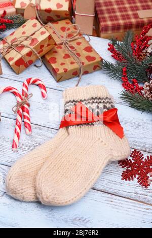 Composition of warm socks with Christmas decorations on white wooden background Stock Photo