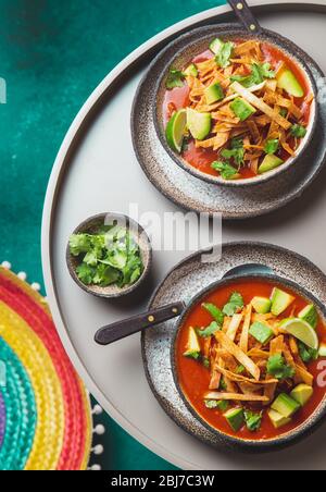 Mexican style table with spicy aztec soup with fried tortilla. Sopa azteca. Stock Photo